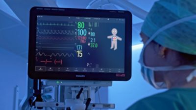 Un clínico observando una pantalla de monitorización de pacientes Philips con signos vitales en tiempo real en un entorno quirúrgico