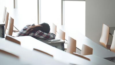 窓際の誰もいない教室で昼寝をする生徒たち