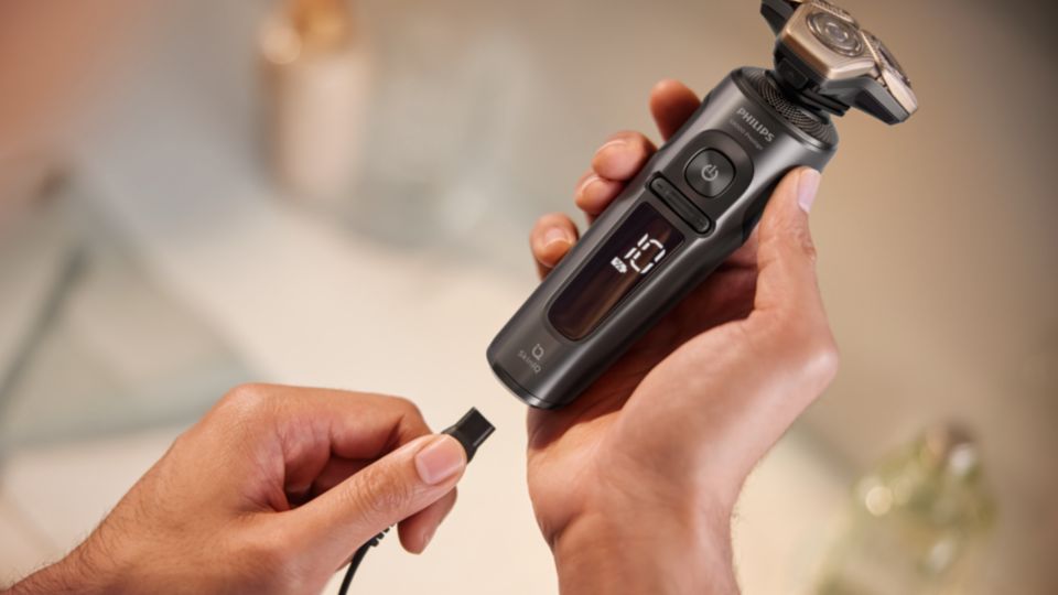 The Philips Shaver 9000 Prestige held in a hand about to be charged.