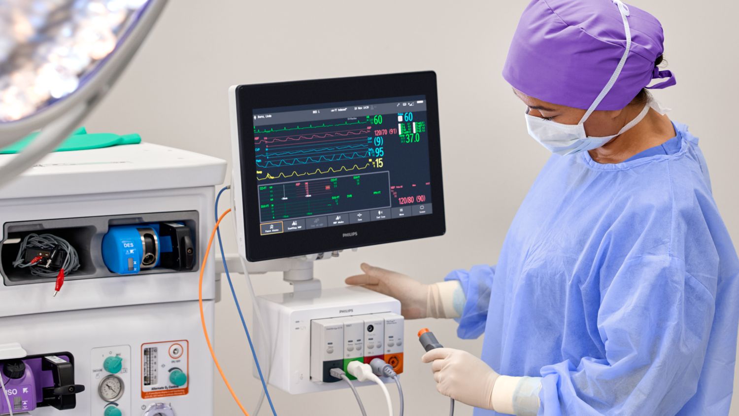 Clinician plugging in FloTrac pressure cable into module rack with monitor mounted
