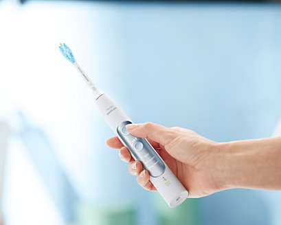 Hand holding a Philips Sonicare ExpertClean power toothbrush