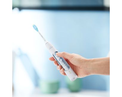 Hand holding a Philips Sonicare ExpertClean power toothbrush