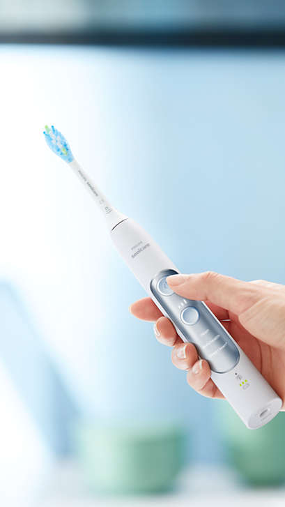 Hand holding an ExpertClean power toothbrush