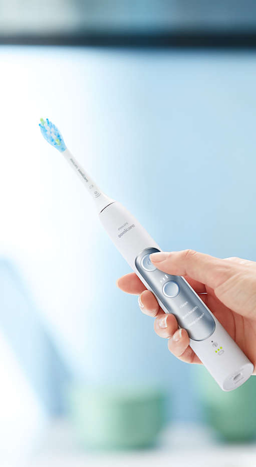 Hand holding an ExpertClean power toothbrush