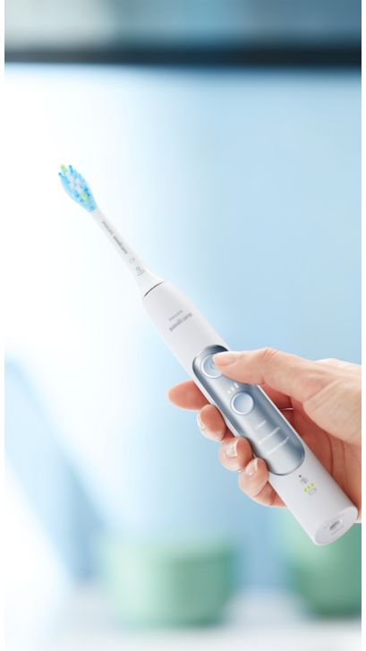 Hand holding an ExpertClean power toothbrush