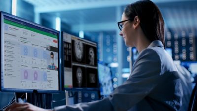 Un especialista trabajando en el Centro de Comando de Operaciones de Radiología de Philips revisando datos de imágenes en monitores