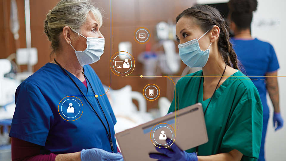 Nurse and doctor conferring with tablet with data overlays