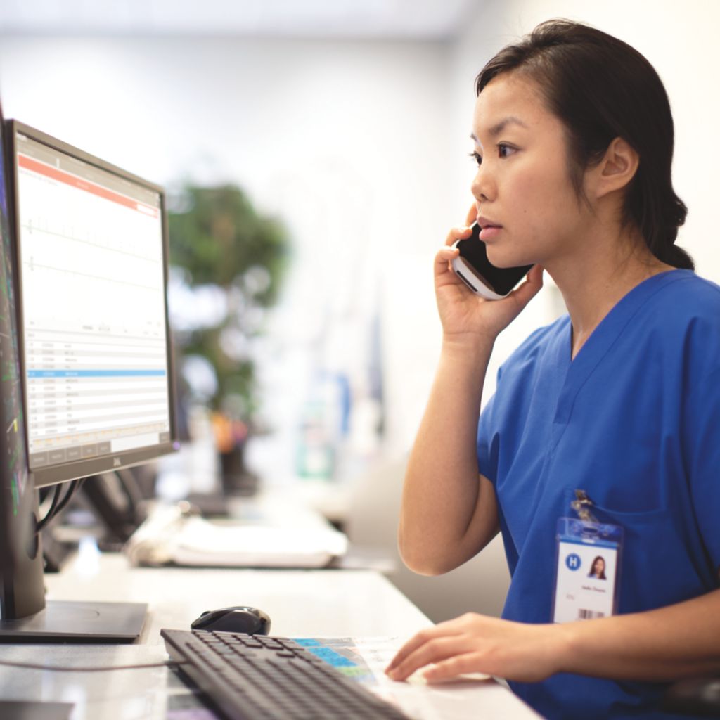 Technician speaking on phone at computer desk