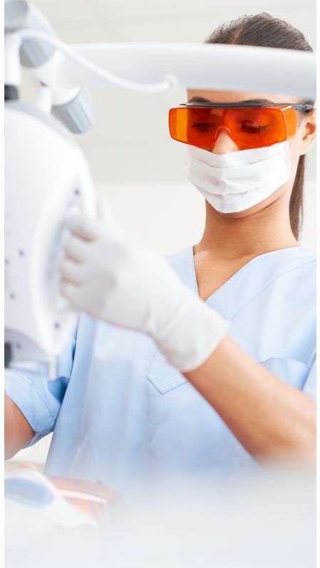 A dental professional adjusting a Philips Zoom! WhiteSpeed lamp