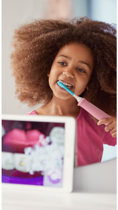 Girl using a Sonicare For Kids power toothbrush
