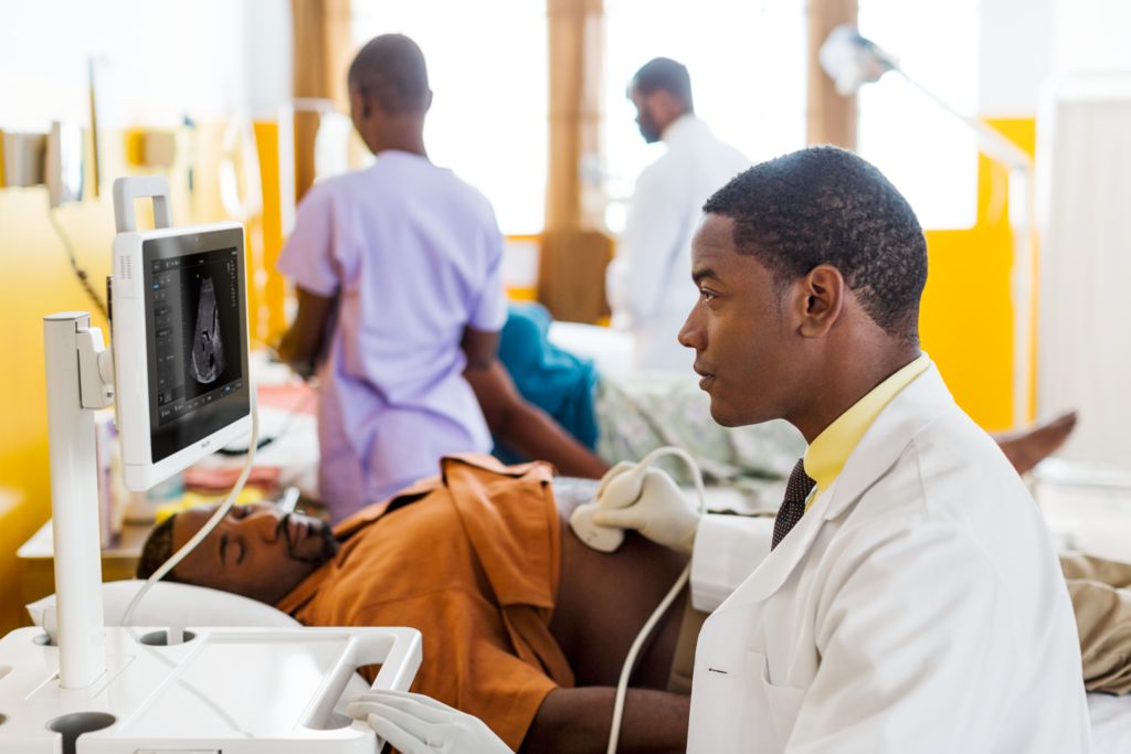 Doctor scanning abdomen of patient