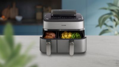 Airfryer mit Dual-Körben beim Garen von Fleisch, Kartoffeln und Gemüse