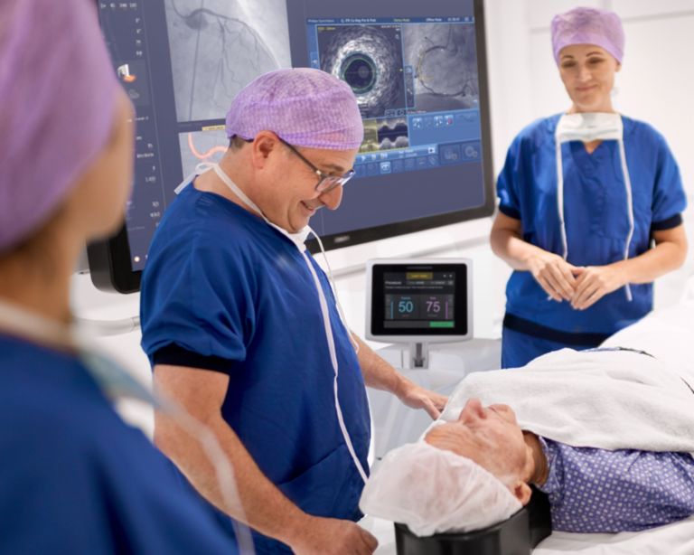 Clinicians in interventional suite preparing artherectomy patient