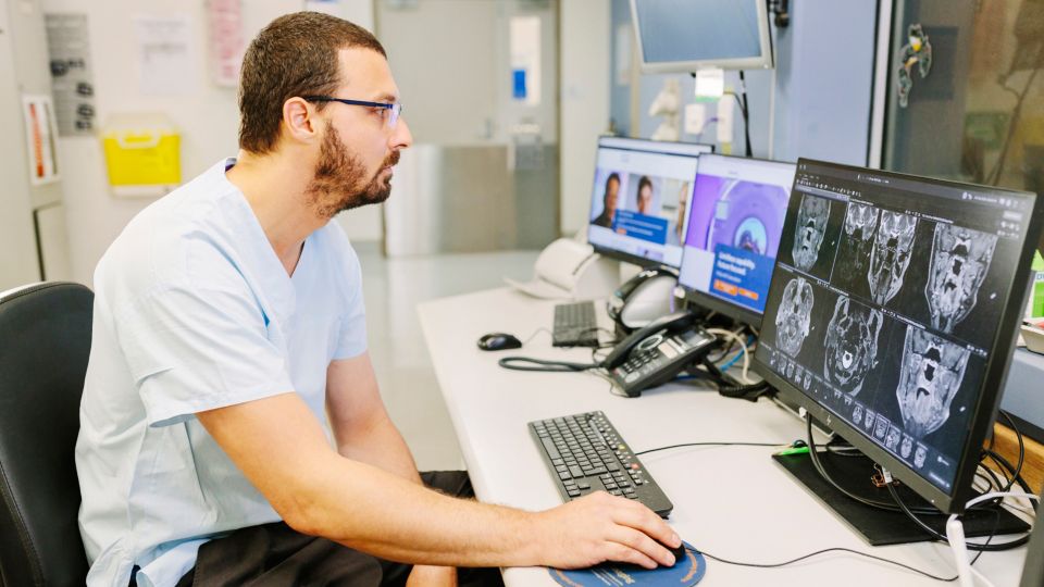 Jack Feeney, head of MRI at Royal Darwin Hospital behind the screen looking at MR images