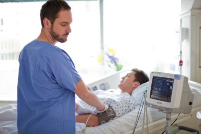 A male nurse monitoring patient vital signs