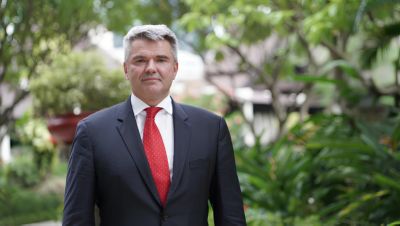 Prof. Dariusz Dudek standing outdoors in a formal suit and red tie