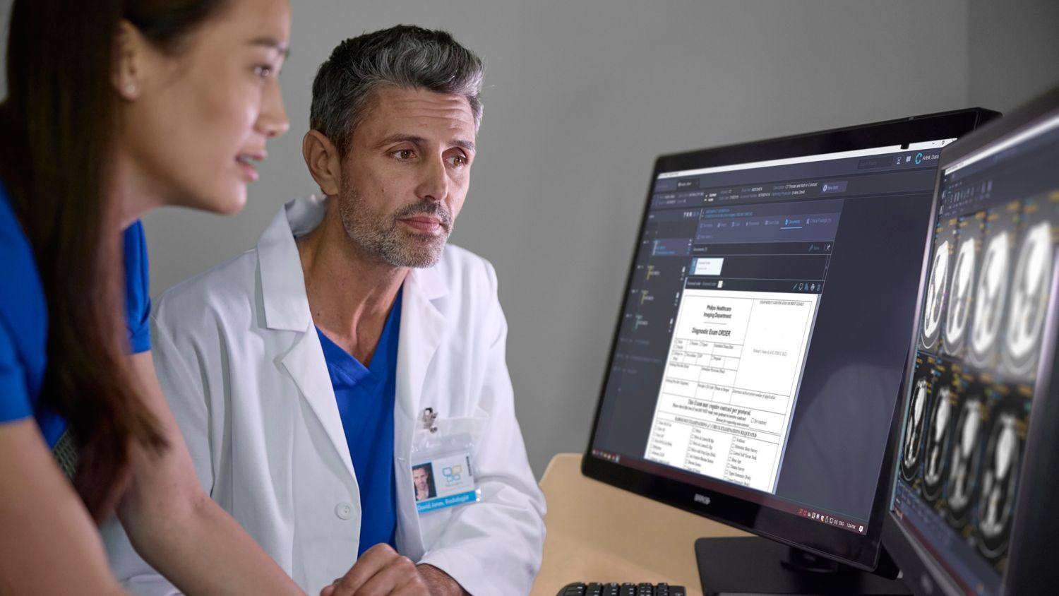 Radiologist and technician reviewing screen