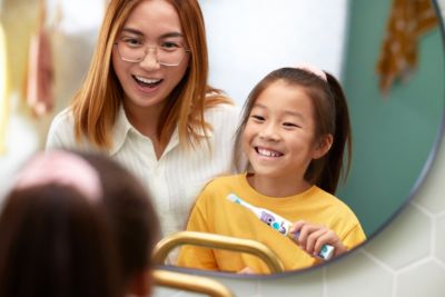 Madre y niña cepillándose los dientes con el nuevo Sonicare for Kids Pets