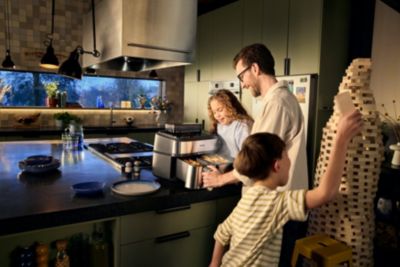 Familie nutzt gemeinsam den Airfryer in der Küche