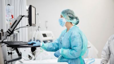 A healthcare worker using computer in ICU