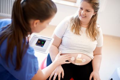High BMI mom on yoga ball with beltless pod and patch, ISP on ipad