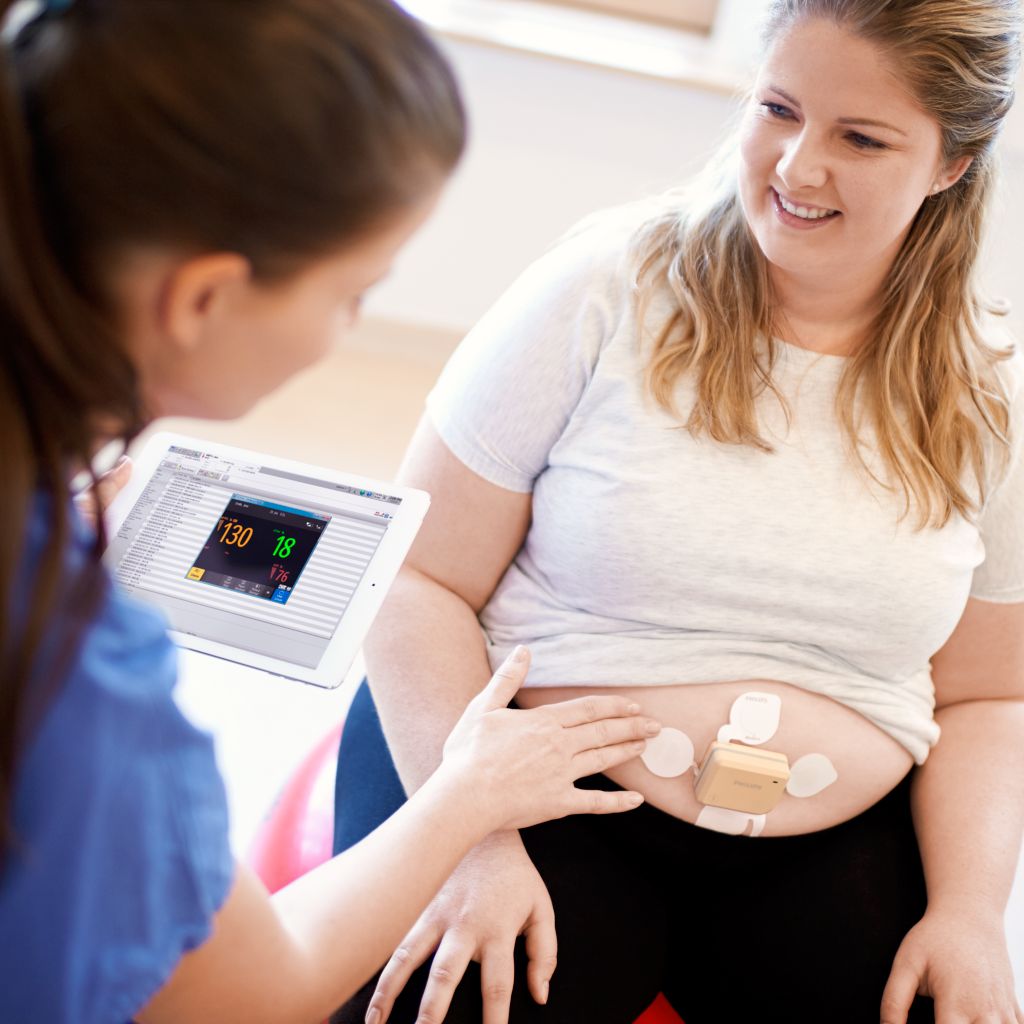 High BMI mom on yoga ball with beltless pod and patch, ISP on ipad