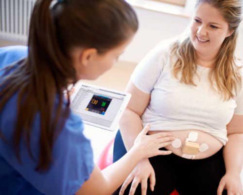 Moeder met hoog BMI op yogabal met riemloze pod en patch, ISP op ipad