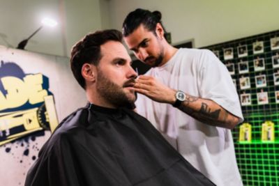  Friseur, der während einer Pflegesitzung einen Schnurrbart stylt