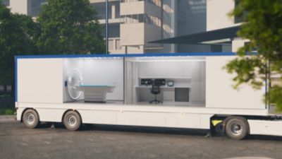Mobile trailer housing Philips CT imaging suite with scanner and control workstation parked outside a hospital