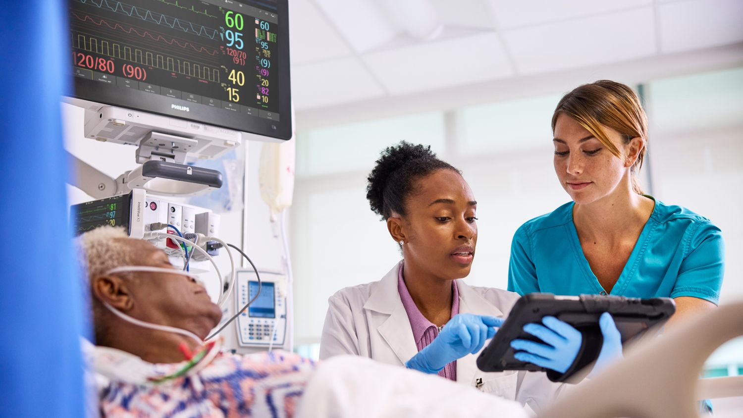Clinicians discussing care needs of patient at bedside
