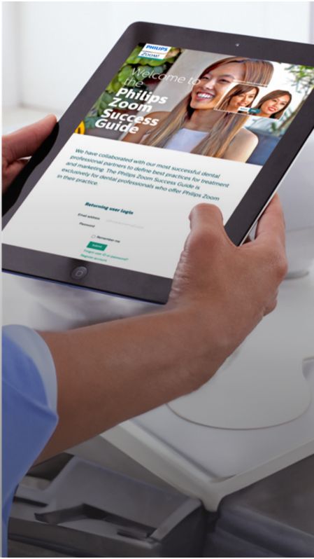 Zahnmediziner hält ein Tablet, auf dem Philips Zoom! zu sehen ist