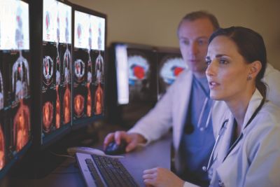 Clinicians reviewing advanced medical imaging on multiple monitors using integrated analysis software