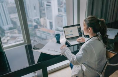 Doctor Working on Laptop by Window