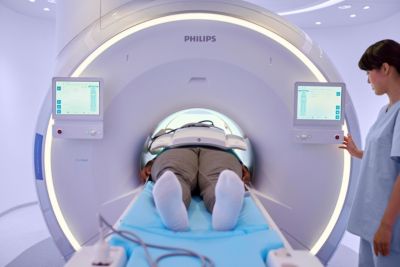 Paciente sometido a exploración radiológica en un sistema de resonancia magnética Philips mientras el médico realiza la monitorización