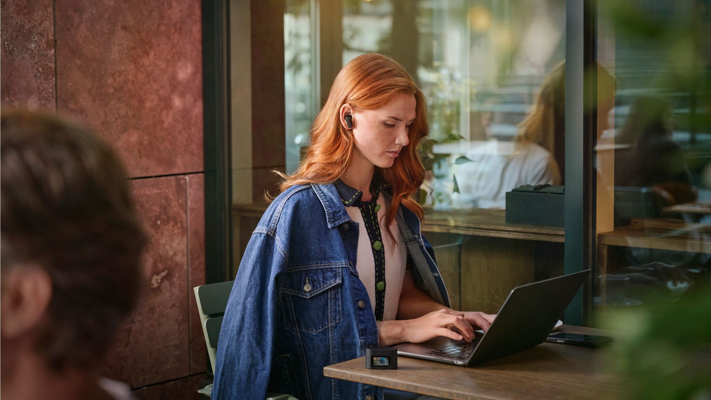 Woman wearing Philips over ear noise canceling headphones in a noisy room
