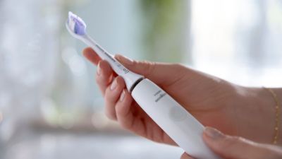 ブラシヘッド付きのソニッケアー歯ブラシを持っている人