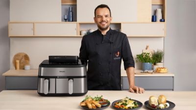 Koch Steffen Henssler steht neben dem Philips Airfryer der 5000er Serie