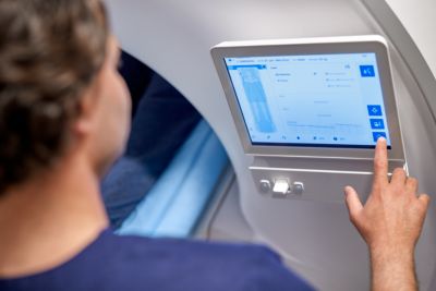 Clinician using Philips MR 5300 touchscreen to start automated MRI exam