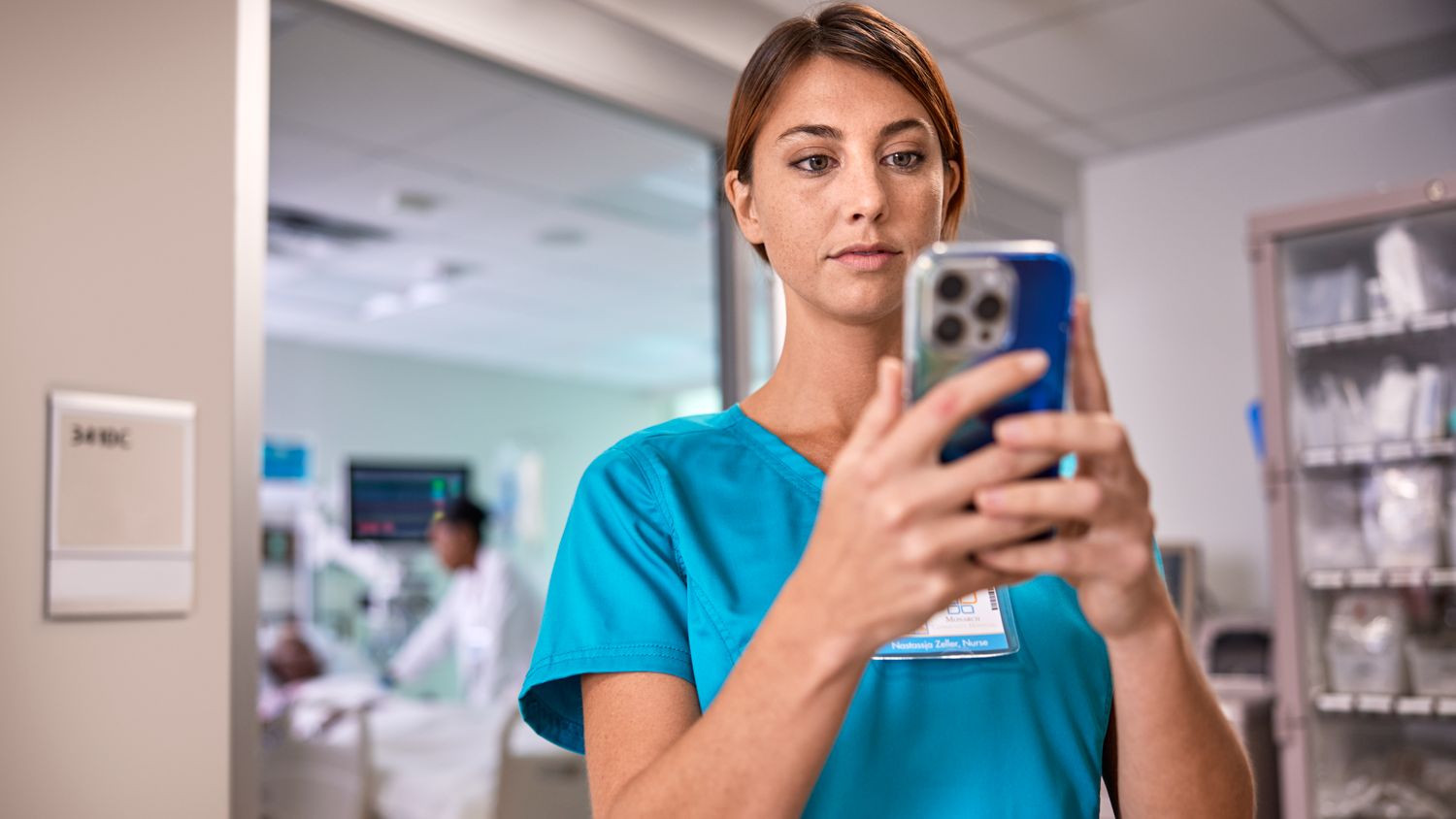 Nurse close-up checking mobile after leaving ICU
