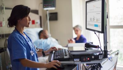 Doctor looking at female patient data on screen