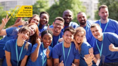 A diverse group of healthcare professionals wearing blue shirts celebrating gender equality