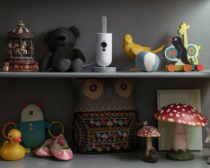 Baby monitor on the shelf between toys