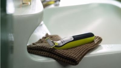 Elektrischer Friseur, der auf einem Handtuch neben einem Waschbecken ruht