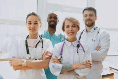 Clinicians standing together with stethoscopes in a clinical setting