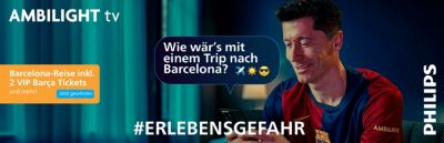 Person nutzt Smartphone mit eingeschaltetem Ambilight-TV im Hintergrund