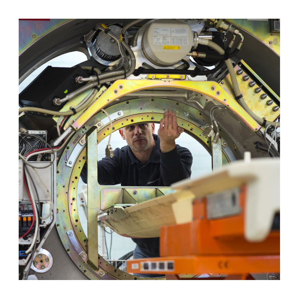 A service technician works on a refurbished system in a factory.