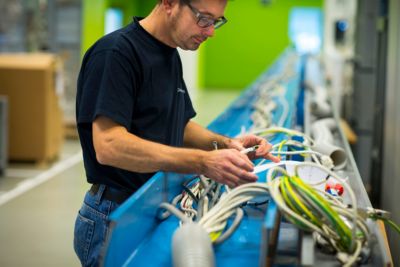 Philips employee assembling and inspecting cables at a manufacturing facility