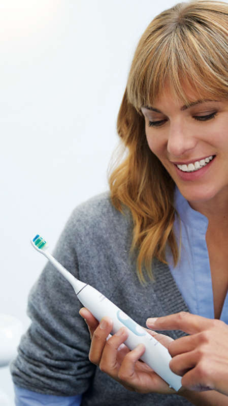 Dental professional showing how to brush Sonicare power.