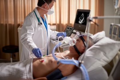 Clinician performing cardiac ultrasound scan on patient in critical care setting