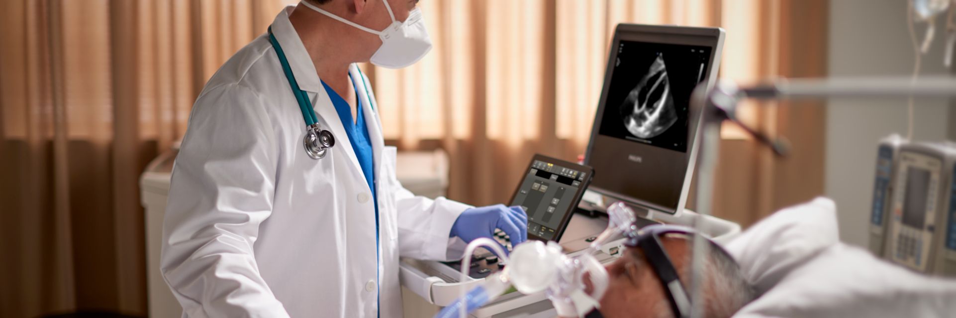 Clinician performing cardiac ultrasound scan on patient in critical care setting
